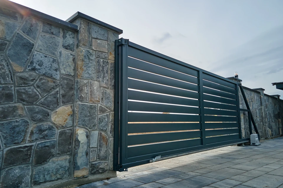 Scène extérieure d'un complexe résidentiel moderne avec portail coulissant automatique en aluminium gris